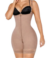 Woman wearing a beige shapewear garment over a black bra on a plain background